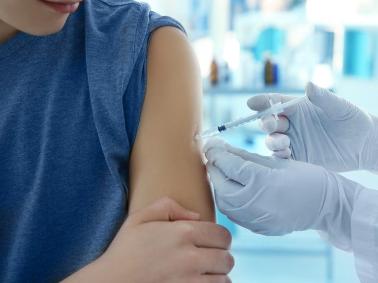 Doctor vaccinating patient in clinic, closeup